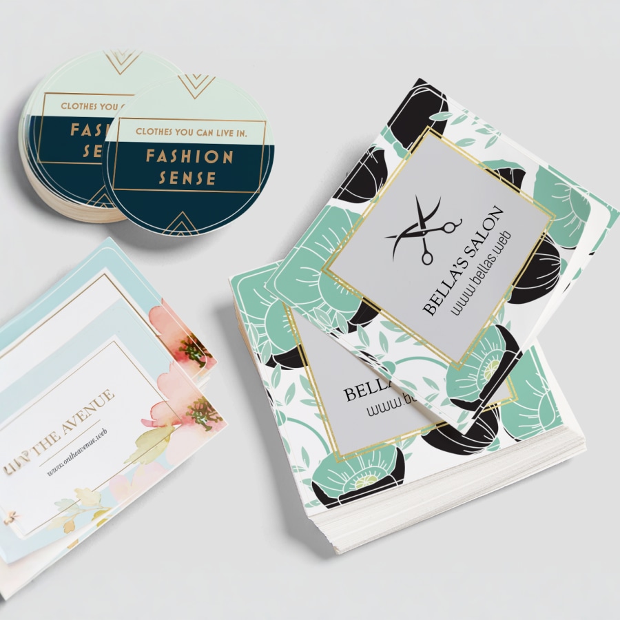 Stacks of square and circle sticker singles advertising clothing retail and salon businesses.