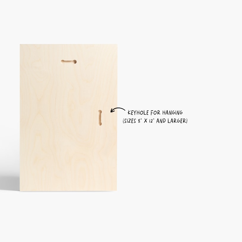 The back of a custom wood print, with a note that print sizes 8" x 12" and larger have keyholes for hanging. 