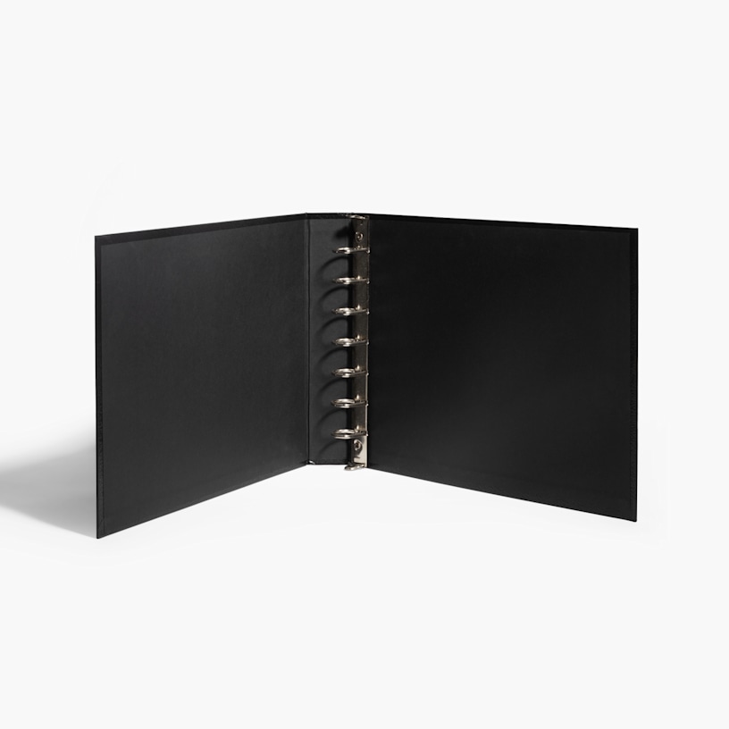 A black 7-ring check binder sitting open on a white backdrop.
