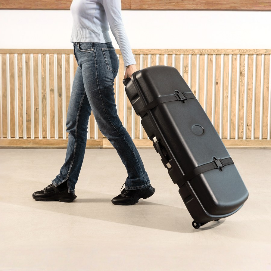 A woman wheeling out the carrying case of the case-to-podium kit.