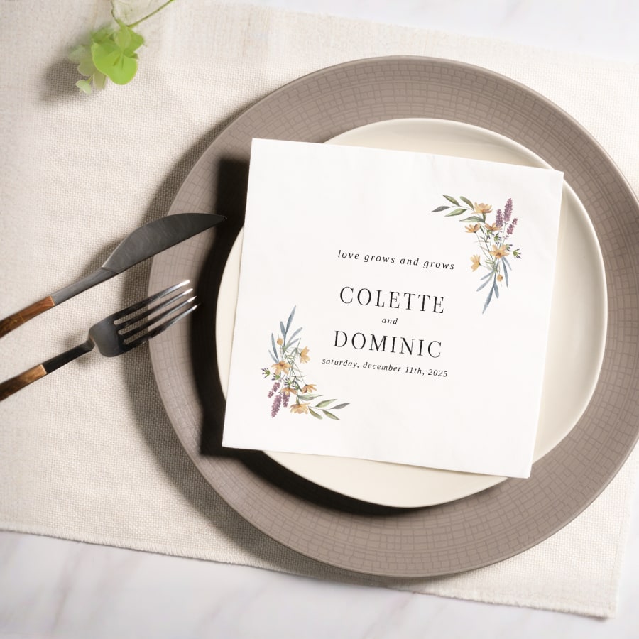 A floral napkin personalized for a wedding, with the couples’ names and wedding date. 