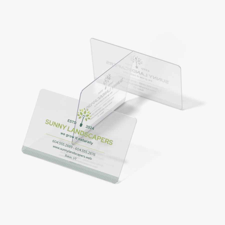 A stack of clear plastic business cards for a landscaping business.