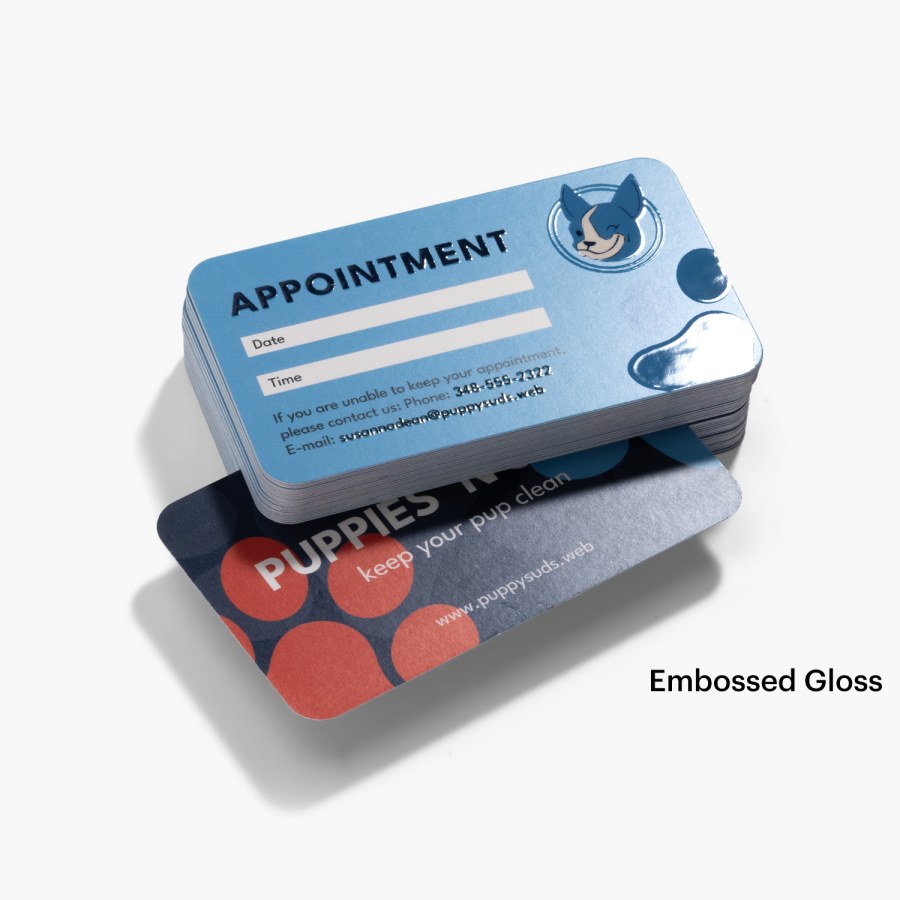 The front and back of an embossed gloss appointment card for a pet grooming service.