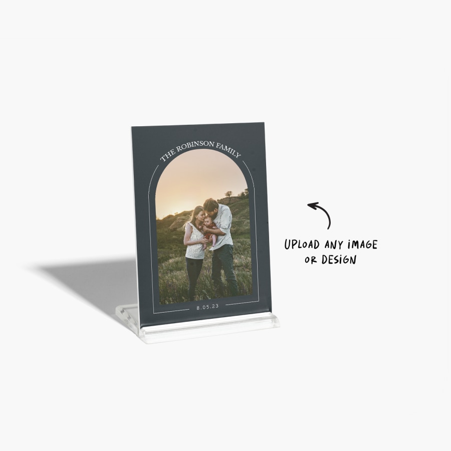 A photo tile printed with a photo of a couple and their baby. The photo is framed by an arch motif.