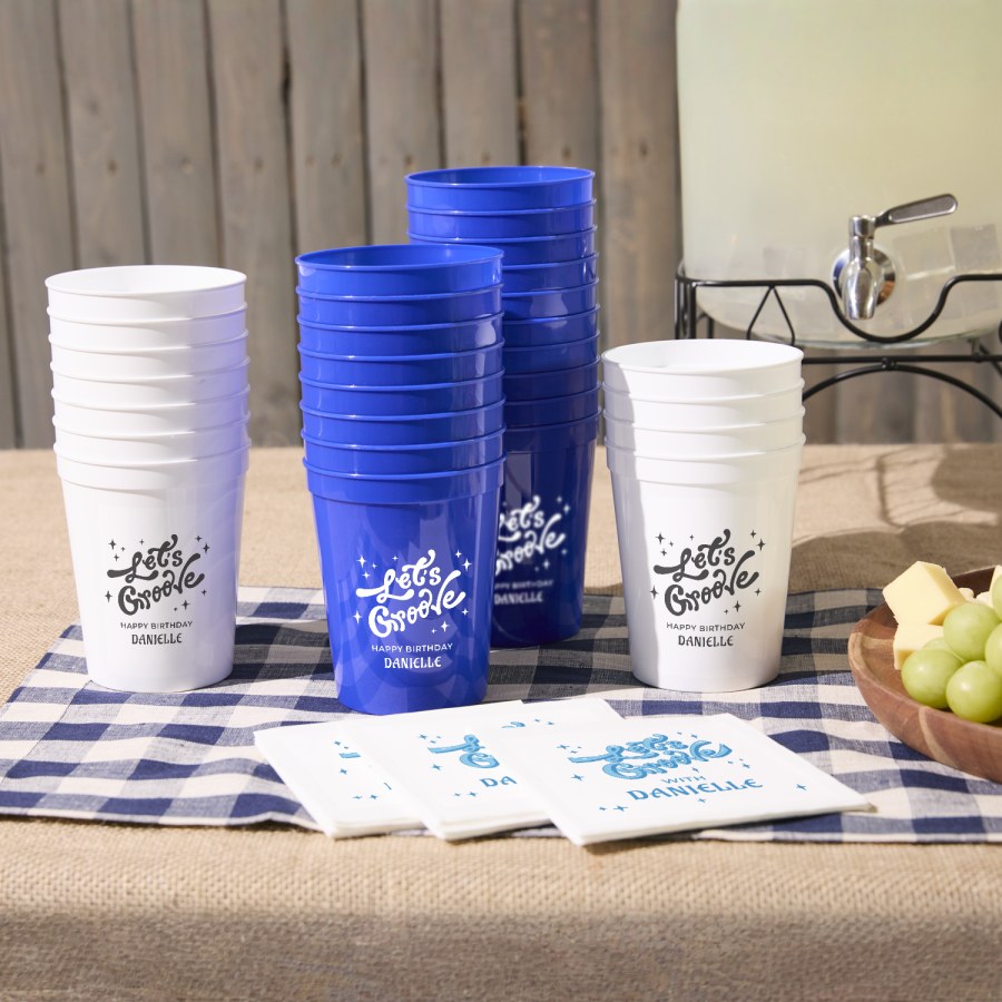 Custom stadium cups stacked on a party table, personalized with the message, “Let’s groove.”