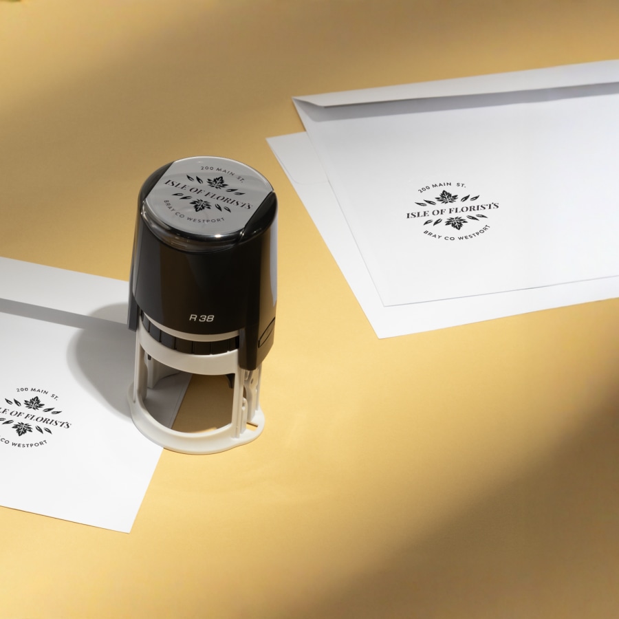 A round stamp from a florist being used to mark envelopes.