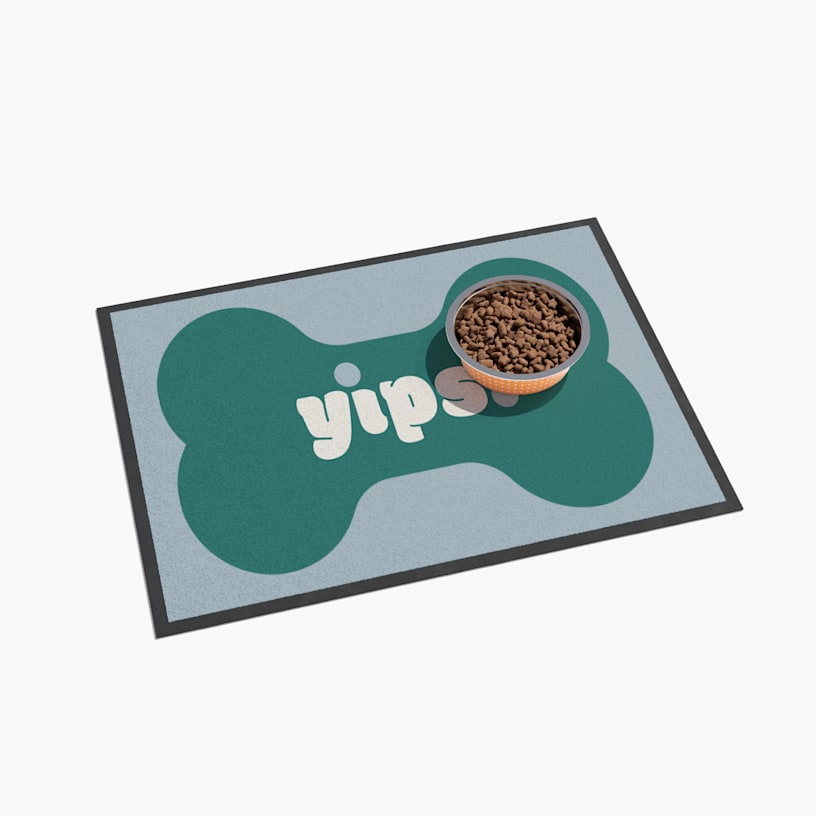 A dog bone floor mat with a dog bowl filled with food on it.