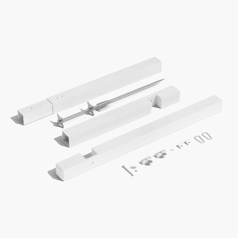 A white colonial post showcasing all the parts needed for assembly on the ground.