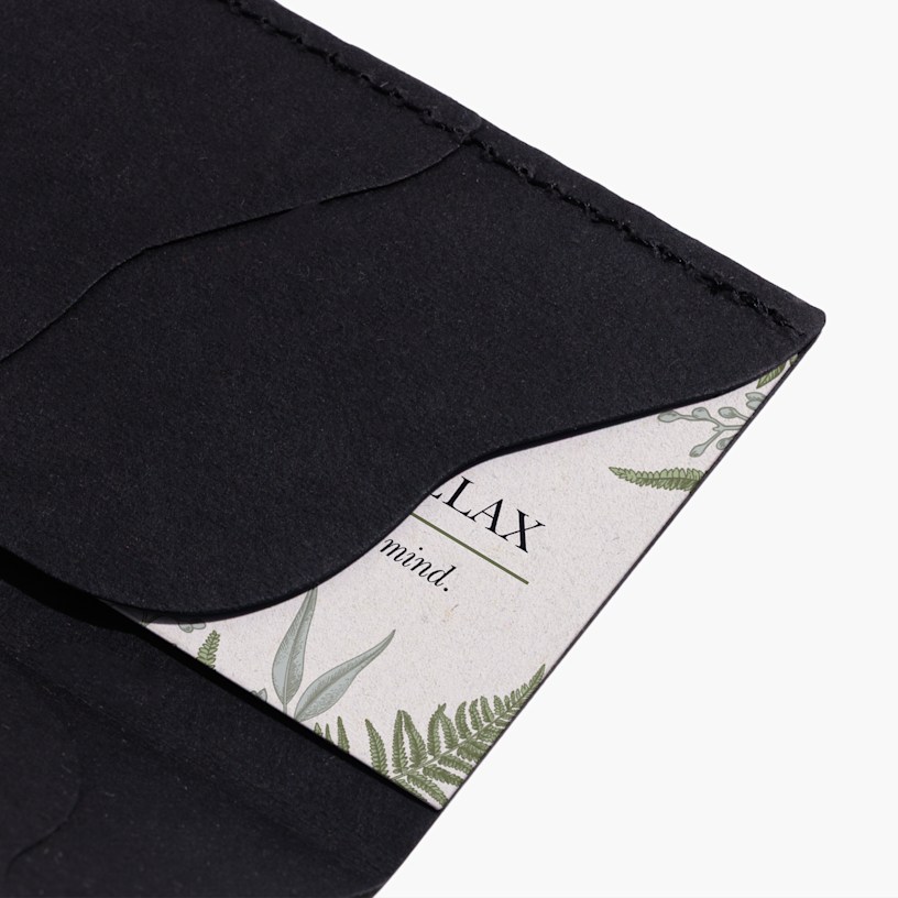 A person holding a slim black business card holder.