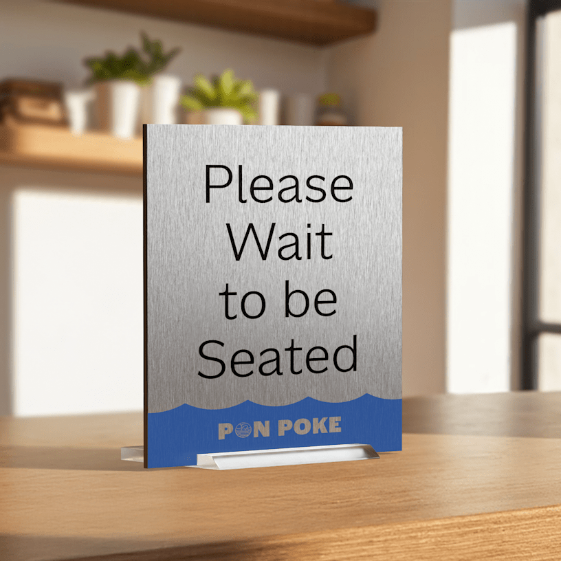  A poke bowl restaurant metal table sign letting customers know they should wait to be seated.
