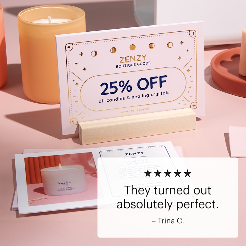 A raised foil postcard in a wooden holder on a display counter.