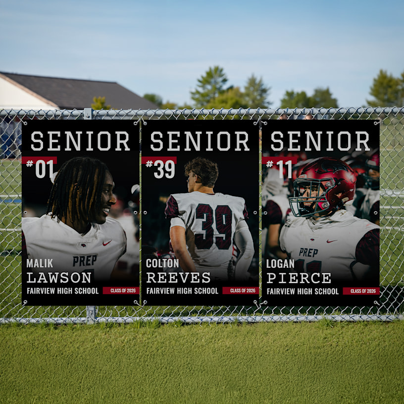 3 vinyl banners hung up on a fence of senior high school football players with their stats.