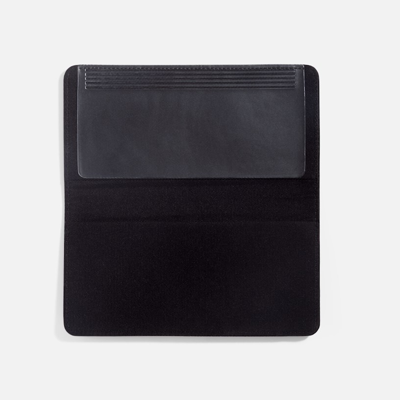 A black leather checkbook cover with a writing flap lying open on a white background. 
