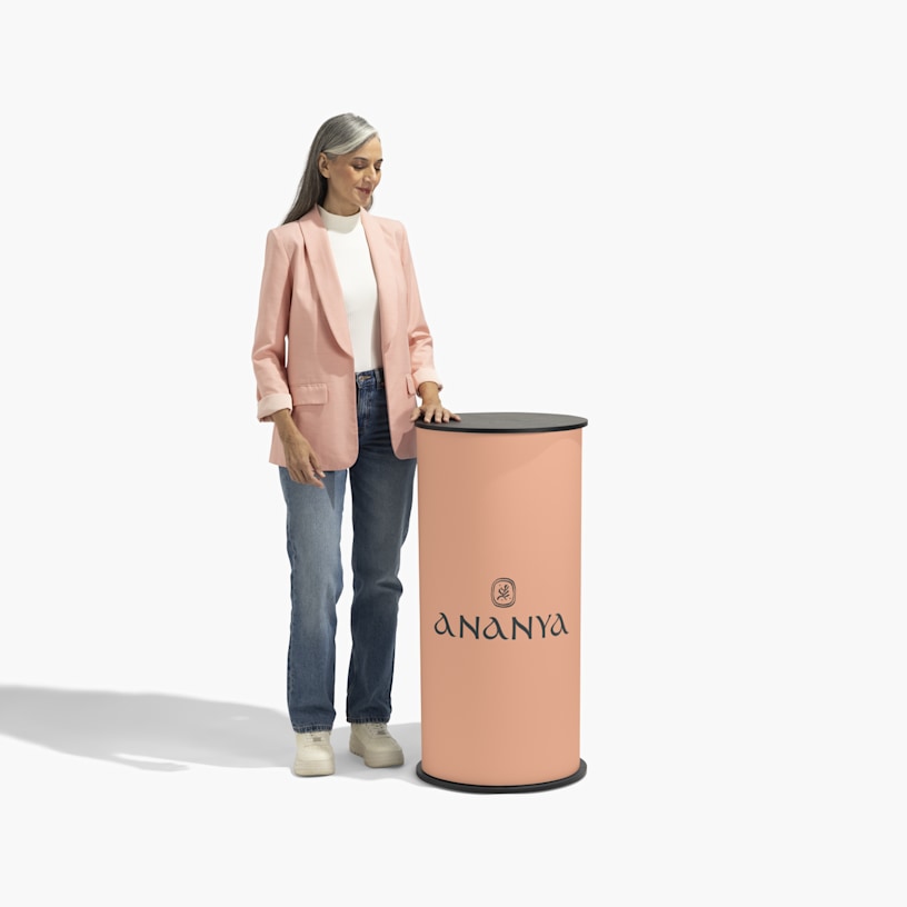 A woman standing next to a peach colored round podium counter.