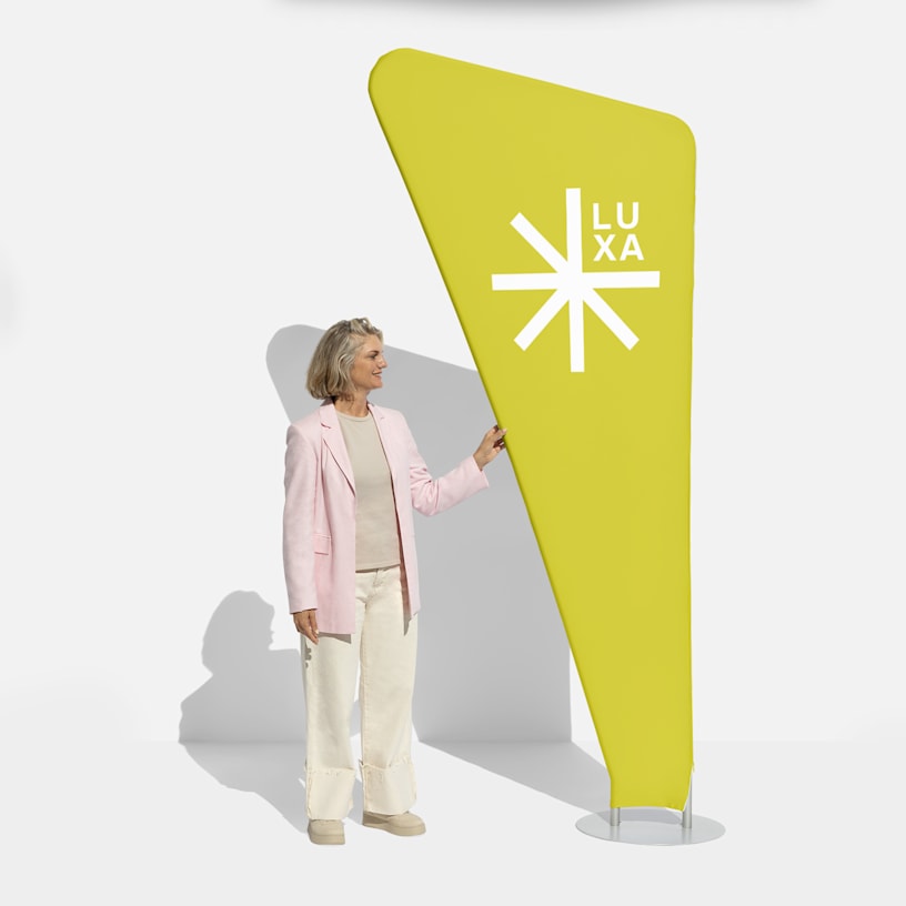 A bright yellow triangle zipper banner with a woman standing next to it for scale.