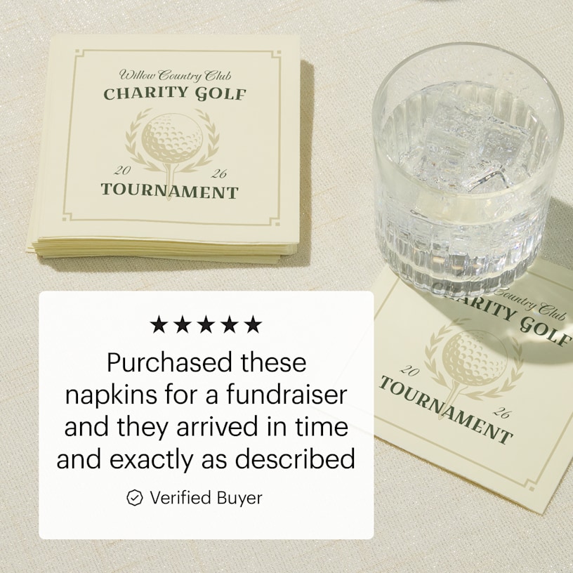 Napkins personalized for a charity golf tournament stacked next to a glass of water. 