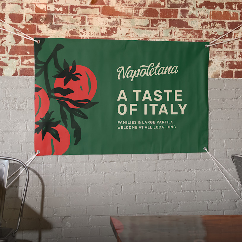 A vinyl banner hanging on a wall promoting an Italian restaurant. Highlighted benefits include new lower prices, easy upload, 25+ sizes and fast, free shipping.