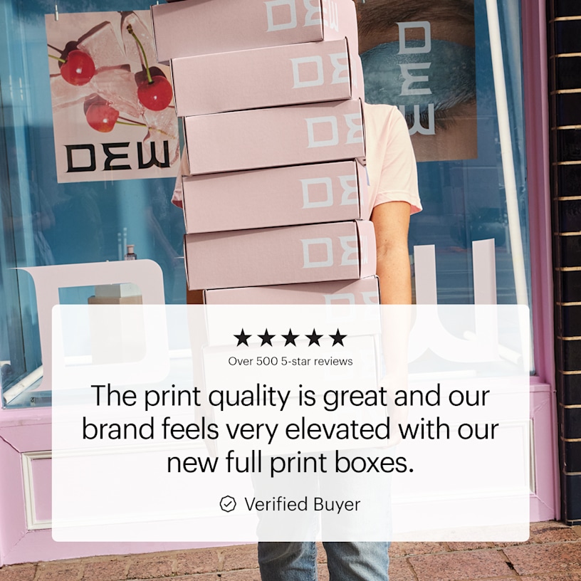 A person holding a stack of full-print mailer boxes in front of a store. A featured customer quote showcases the print quality and elevated brand look.