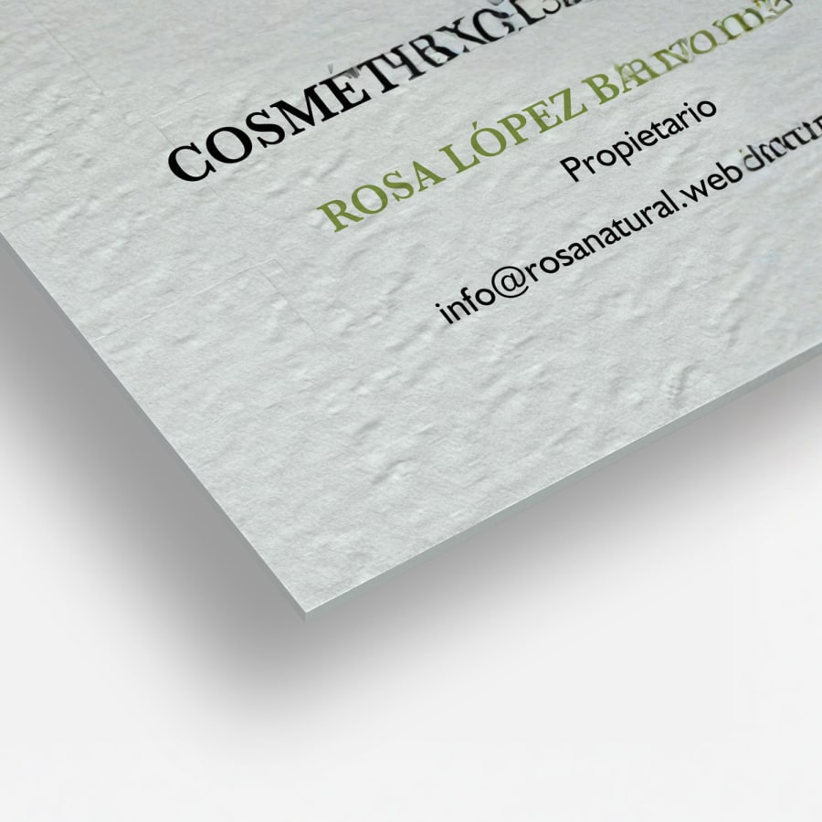 Un primer plano de una tarjeta de visita de textura rugosa, en el que se aprecia las esquinas cuadradas y el tipo de papel con textura similar a un lienzo.