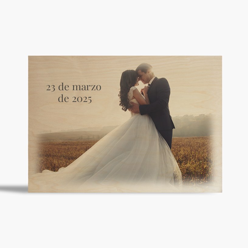 Una foto de boda en bloque de madera, con la novia y el novio abrazados en un campo. 