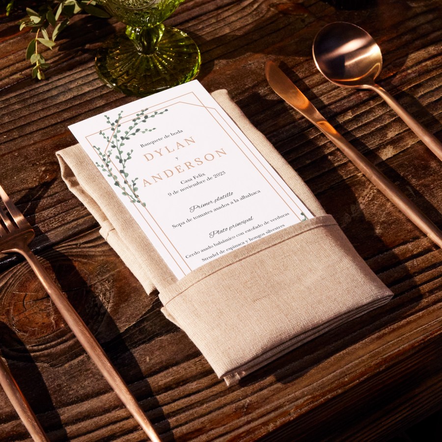 Un menú para bodas con un diseño moderno colocado sobre una servilleta beige en una mesa de madera.