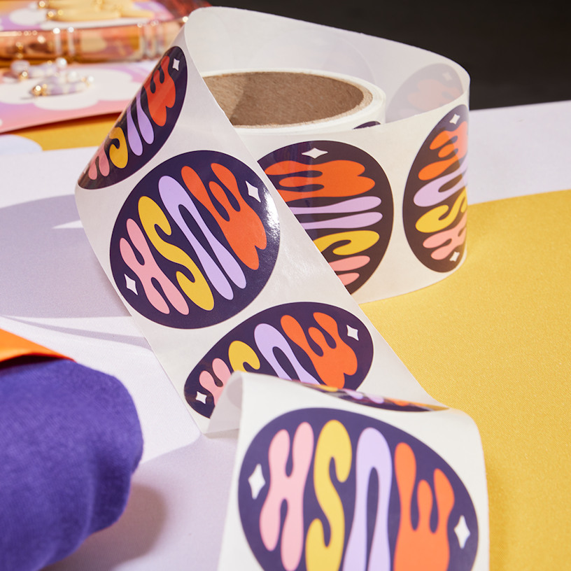 Un rollo de etiquetas adhesivas de una empresa de joyas hechas a mano levemente desenrollado.