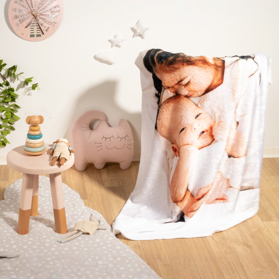 Una manta personalizada impresa con una foto de un niño abrazando a un bebé.