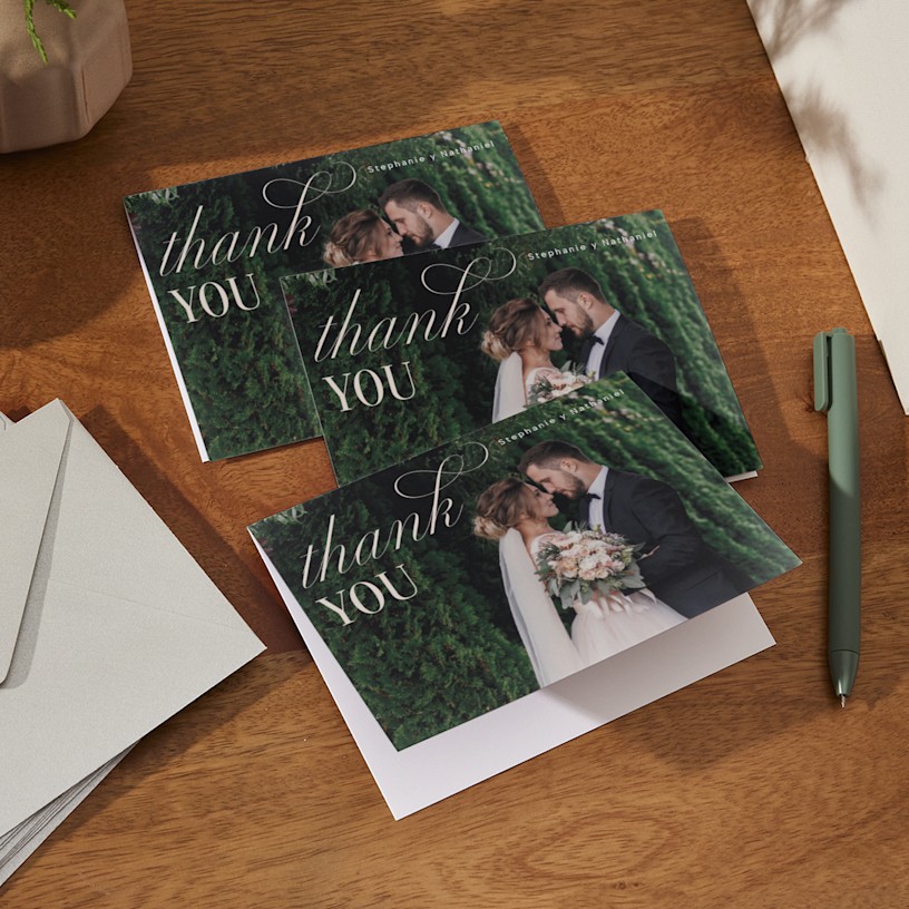 Una pequeña pila de tarjetas de agradecimiento de boda impresas con una foto de la boda. 