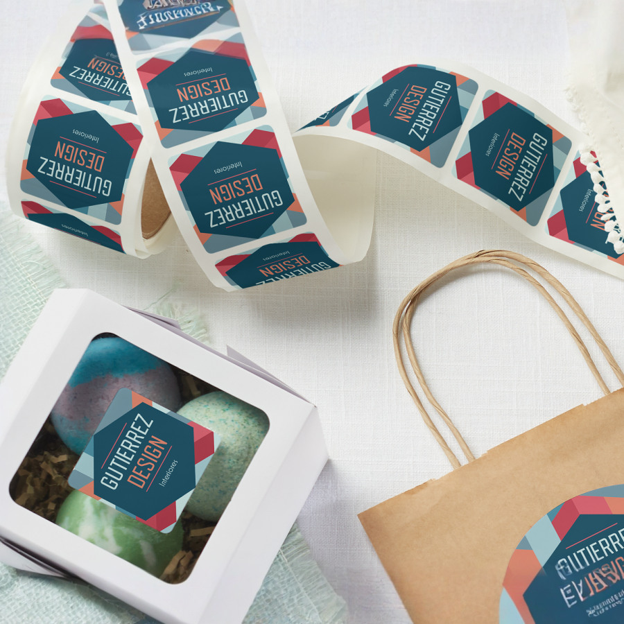 Un rollo de etiquetas para empaque de una empresa de diseño de interiores, unas cuantas han sido colocadas en unas bolsas y cajas.