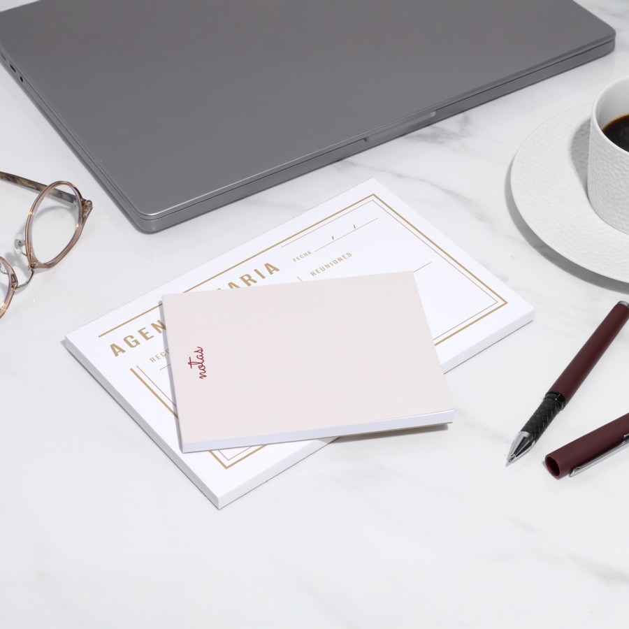 Dos tipos de blocs de notas personalizados sobre una mesa o escritorio.