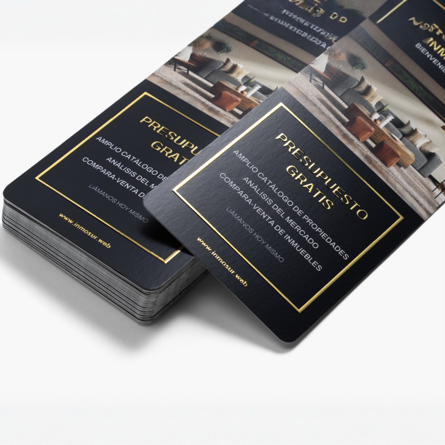 Un conjunto de tarjetas informativas con relieves metalizados dorados promocionando una consulta gratis de una empresa de bienes raíces. 
