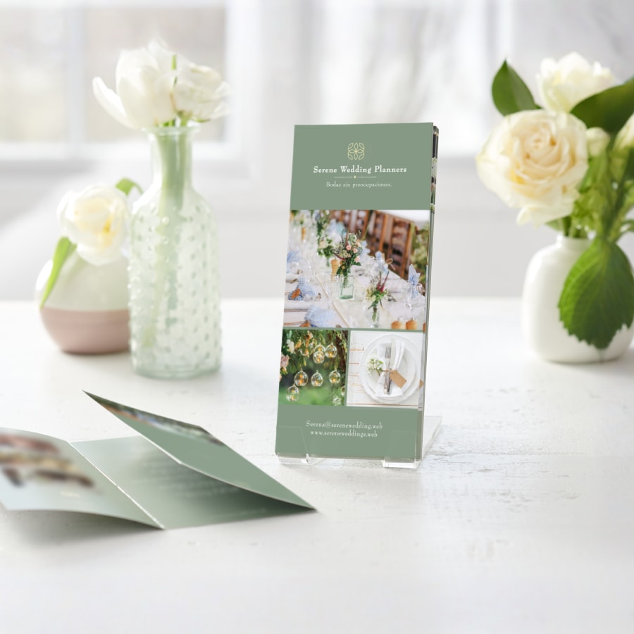 Varios menús trípticos de una empresa de planificación de bodas que se muestran en un soporte de plástico transparente.  