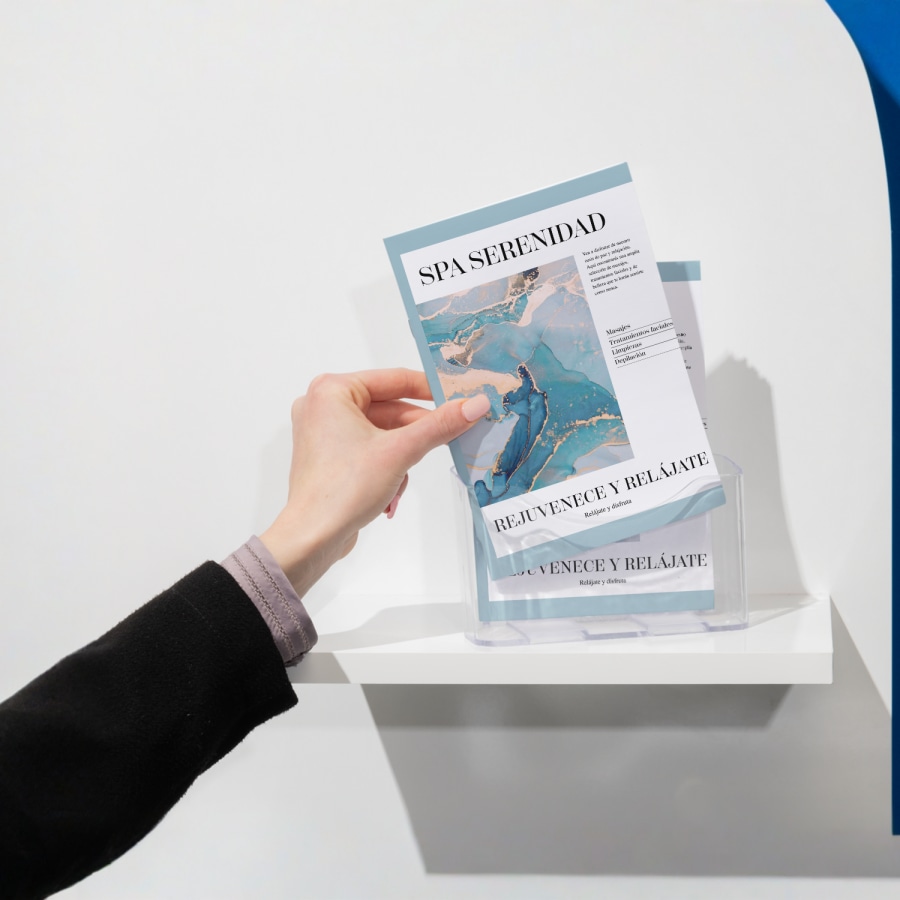 Una persona tomando de un soporte, un cuadernillo encuadernado con grapas de un spa.   