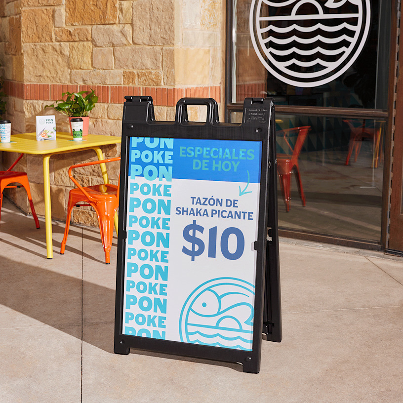  Un letrero Signicade® negro en una vereda promocionando un menú especial de bol de poke.
