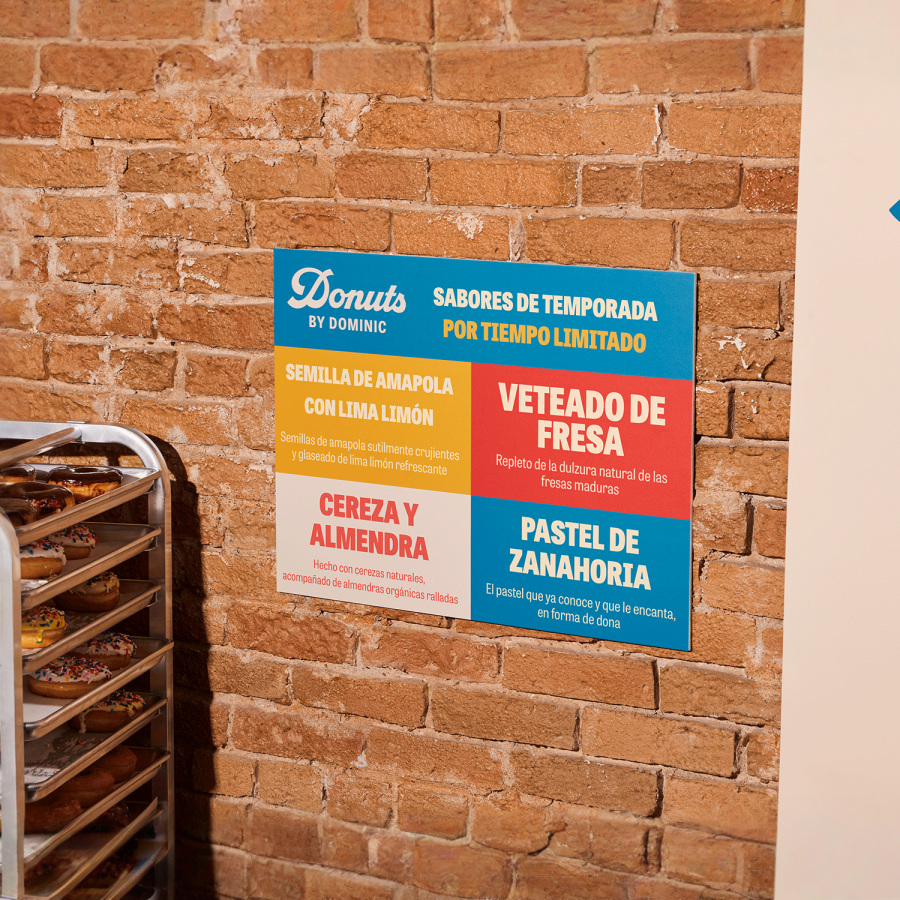 Un cartel de cartón pluma colgado en una pared de ladrillo.