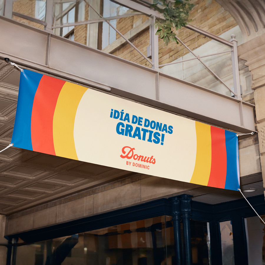 Una lona de vinilo colorida colgada, anunciando donas gratis.