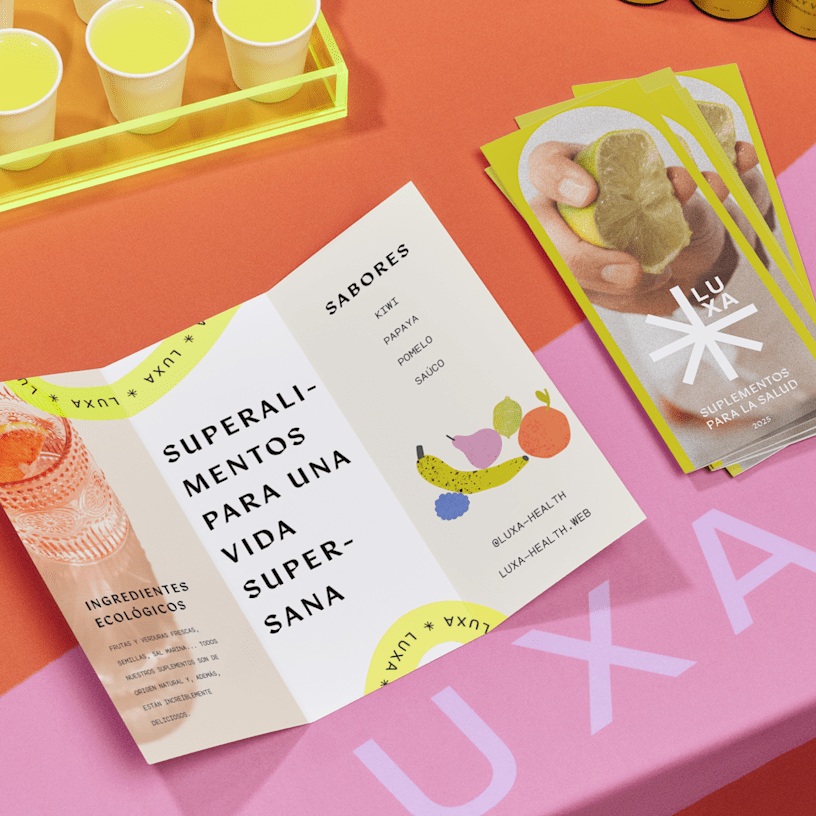 Folletos trípticos de una marca de suplementos de salud se muestran en una mesa colorida, con muestras en el fondo.