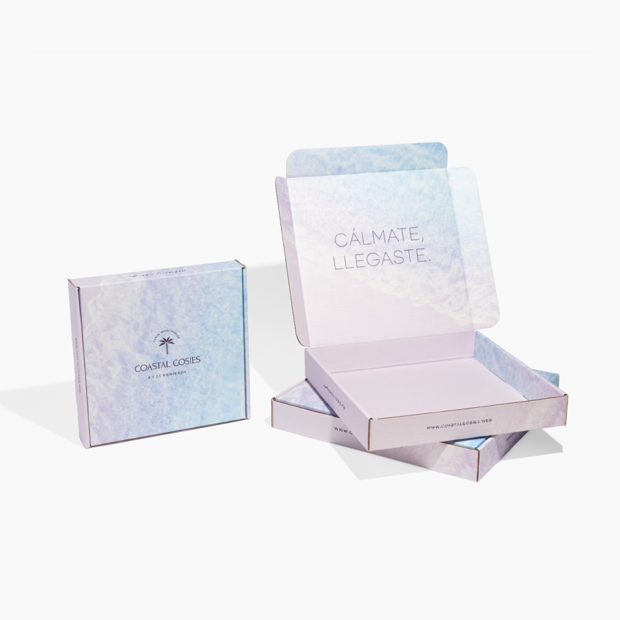 3 cajas postales cuadradas, dos están colocadas de manera plana y la tercera está parada sobre un extremo. La caja plana superior está abierta mostrando el mensaje que lleva adentro.