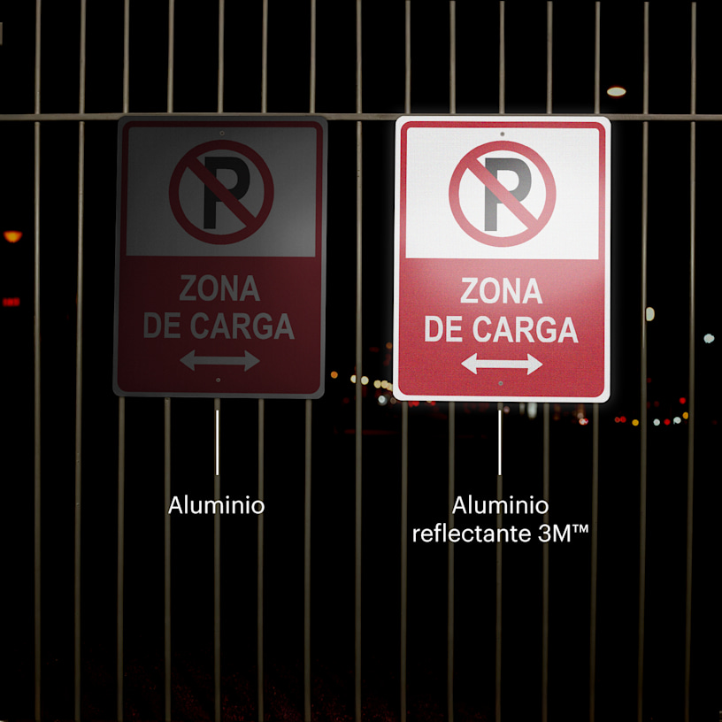 2 letreros para estacionamiento se muestran colgados de una cerca en la noche.