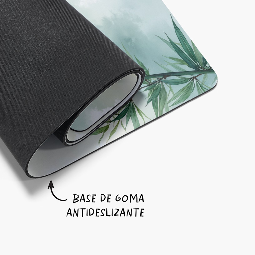 Una esterilla de yoga botánica ligeramente enrollada con una nota que dice que la base está hecha de goma antideslizante. 