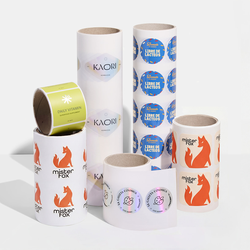 Una variedad de etiquetas adhesivas en rollo de diferentes marcas, mostrando las diferentes formas, tamaños, acabados y tipos de rollos disponibles.