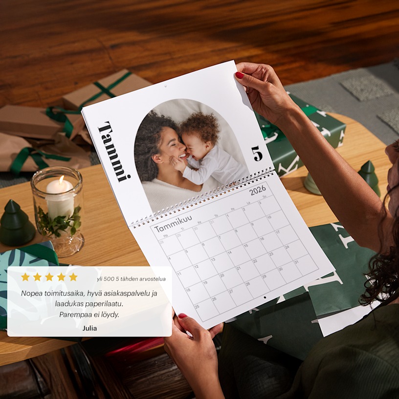 Käsipari pitelemässä personoitua seinäkalenteria, jossa on valokuva äidistä ja vauvasta. 