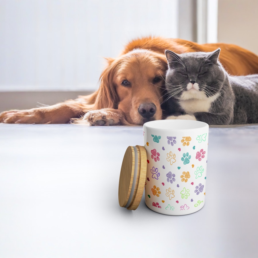 Koira ja kissa katselevat herkkupurkkia, joka on personoitu tassunjäljillä. 