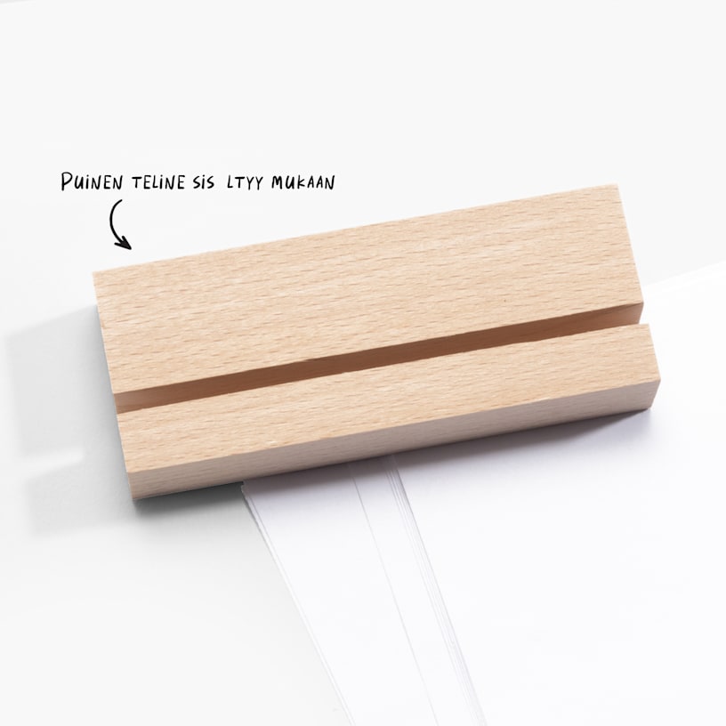 Puinen jalusta, jossa on pöytäprinttiin sopiva rako. Mukana on huomautus siitä, että puinen jalusta sisältyy mukaan. 