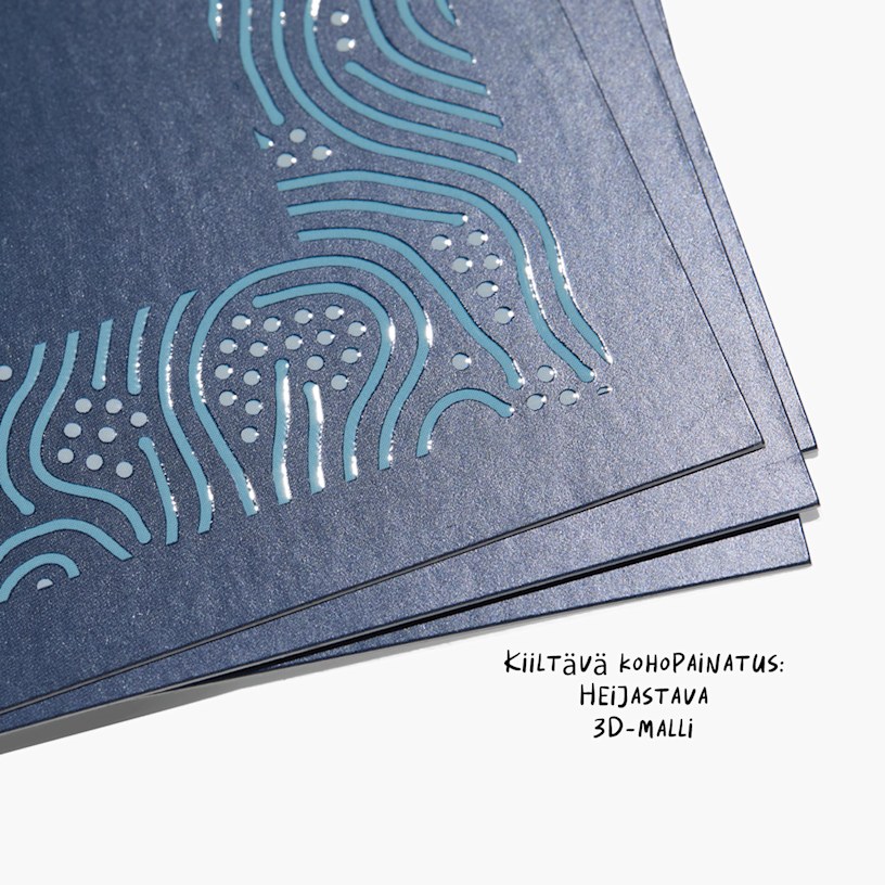 Lähikuva käyntikorteista kohokuvioitujen, kiiltävien kirjainten kohdelakkauksella luoden heijastavan kolmiulotteisen ilmeen.