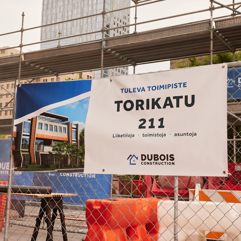 Rakennusfirman banderolli, joka on sidottu rakennustyömaan aitaan ja jossa on tietoja rakenteilla olevasta rakennuksesta.