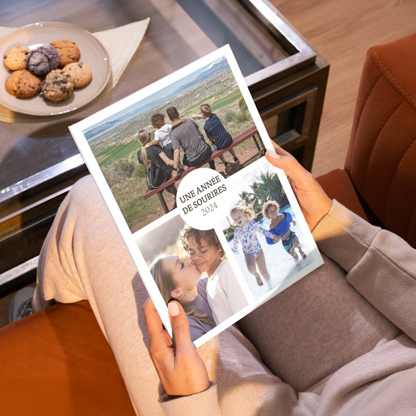 Livre photo fermé avec un pêle-mêle de photos d’une famille sur la couverture. 