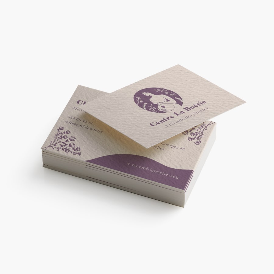 Pile de cartes de visite papier texturé pour un centre de santé destiné aux femmes. Le verso et le recto sont présentés.