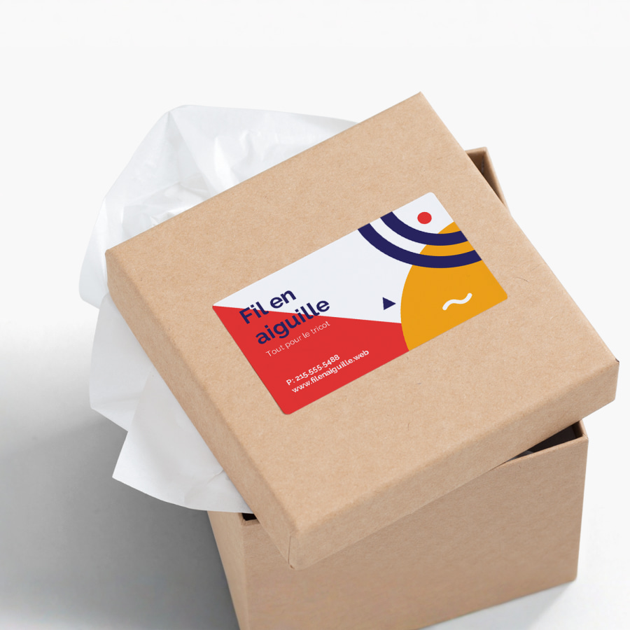 Un colis sur lequel une carte d’affaires autocollante fait la promotion d’une entreprise commercialisant du matériel de tricot et crochet.
