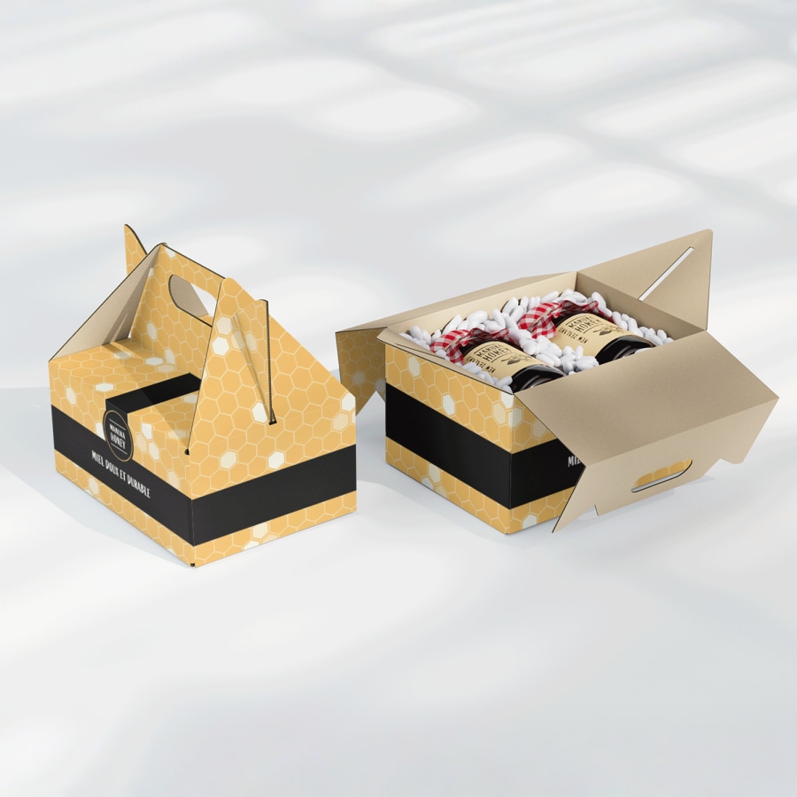  Deux boîtes à pignon personnalisées jaune et noir. L’une des boîtes contient des pots de miel. 